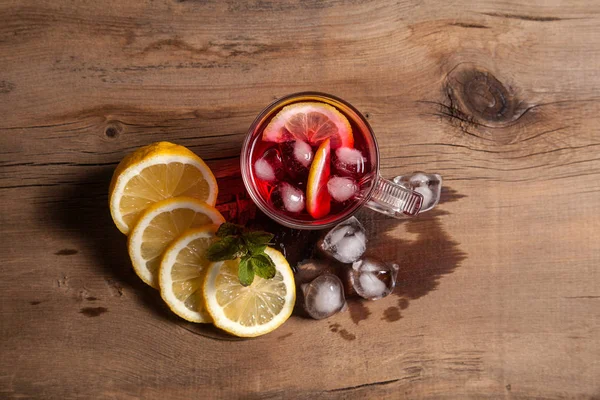 Hibiscus kallt te med is, citron och mynta på vintage trä bac — Stockfoto