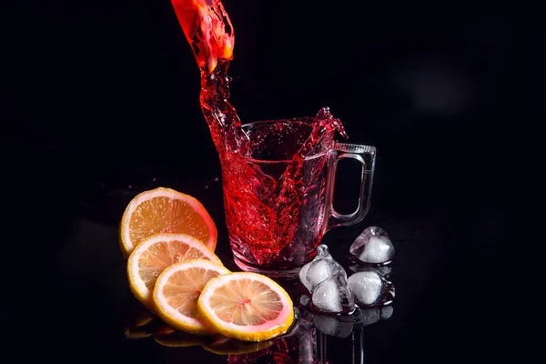 Hibiscus cold tea pouring into glass with ice, lemon and mint is — Stock Photo, Image