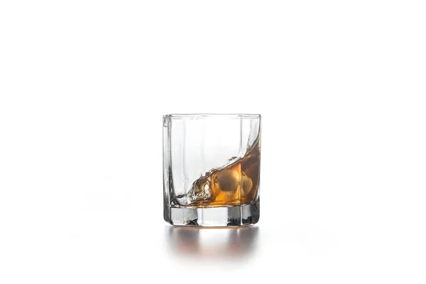 Whiskey splash in glass with ice on light background — Stock Photo, Image