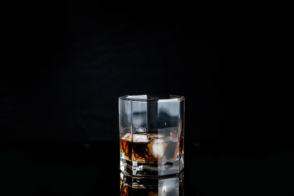 Copo de uísque com gelo isolado sobre fundo preto — Fotografia de Stock