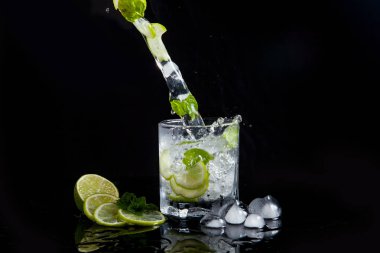 Siyah arka plan üzerinde sıçrama ile yaz kokteyl mojito