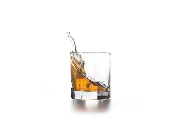 Whisky éclaboussure en verre avec de la glace sur fond clair — Photo