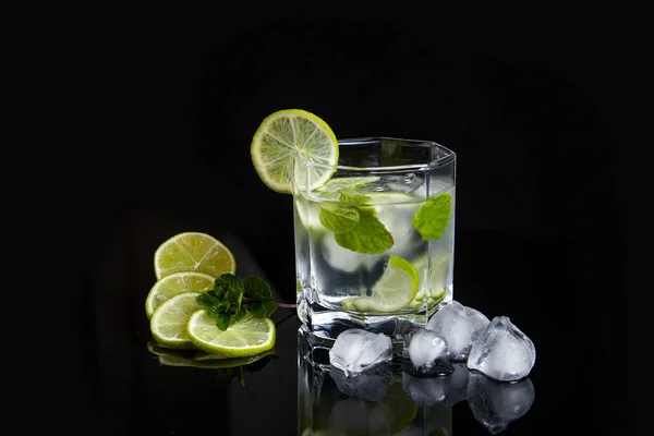 Летний коктейль мохито в стакане, нарезанный лайм и кубики льда на bl — стоковое фото