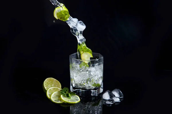 Mojito cocktail estivo con spruzzi su sfondo nero — Foto Stock