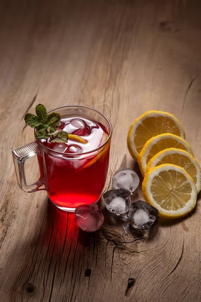 Hibiscus kallt te med is, citron och mynta på vintage trä bac — Stockfoto