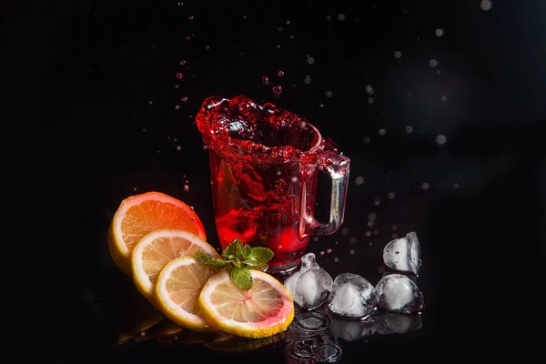 Hibiskus-Kalter Tee spritzt aus dem gefallenen Eiswürfel ins Glas — Stockfoto