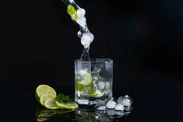 Mojito cocktail estivo con spruzzi su sfondo nero — Foto Stock