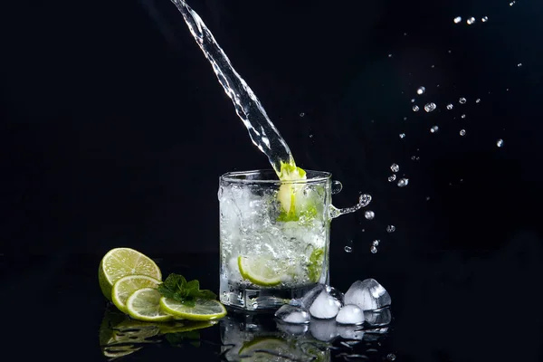 Mojito cocktail estivo con spruzzi su sfondo nero — Foto Stock