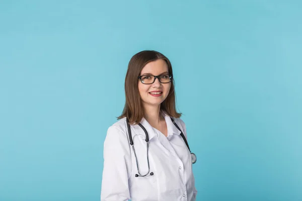 Uśmiechnięta kobieta lekarz medycyny z stetoskop nad niebieskim tle z miejsca kopii — Zdjęcie stockowe