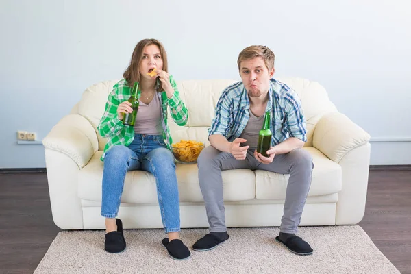 Casal de amigos sentados no sofá assistindo jogo esporte na tv — Fotografia de Stock