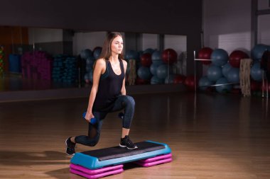 Spor salonunda adım platformda sportif kadın uygulama