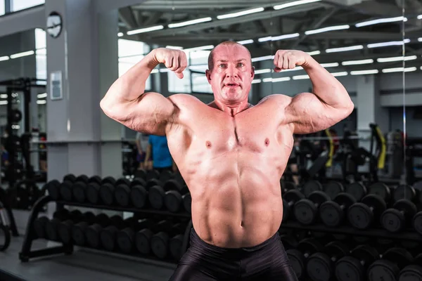 Culturista con bíceps, tríceps y pecho perfectos en el gimnasio — Foto de Stock