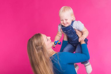 genç anne ve kızı birlikte eğleniyor arka plan pembe