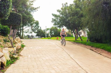 Yakışıklı genç adam Bisiklet ve kask Park güneşli