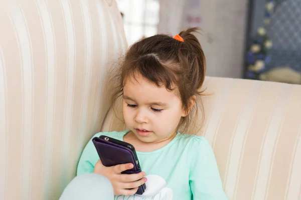 Küçük çocuk kız evde smartphone oyun — Stok fotoğraf