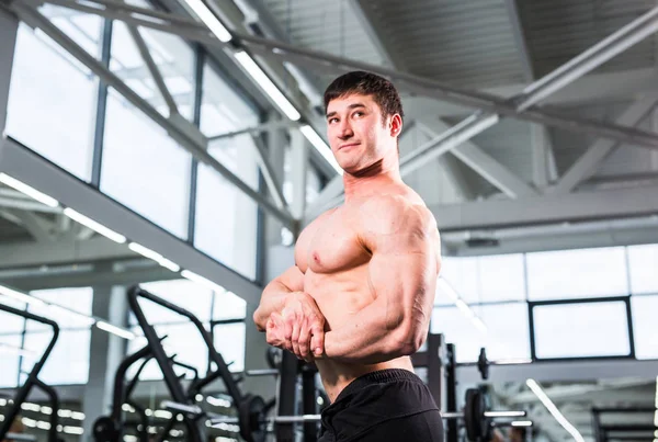 Guapo culturista hombre con grandes músculos en el gimnasio — Foto de Stock