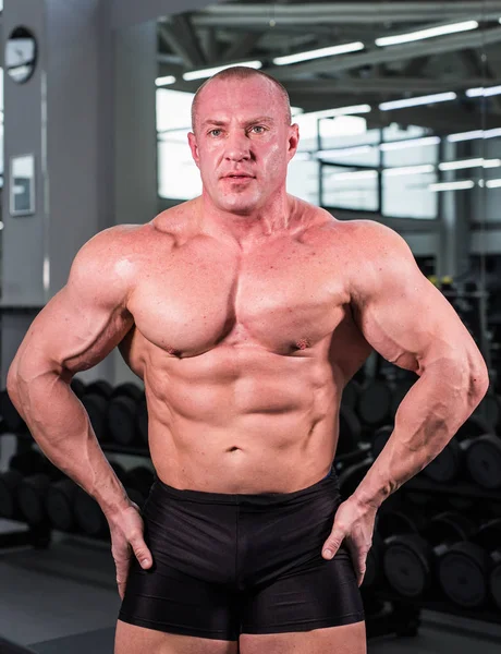 Guapo culturista hombre con grandes músculos en el gimnasio — Foto de Stock
