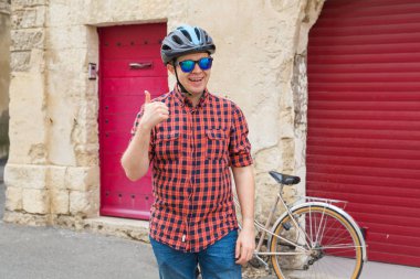 Komik adam kask ve kırmızı açık arka plan üzerinde bir yaşasın vererek güneş gözlüğü