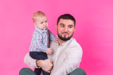 Baba ve oğul pembe bir arka plan üzerinde mutlu portre. Studio