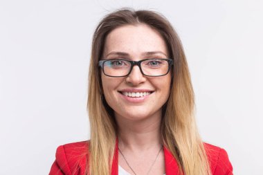 Beyaz arka plan karşı gözlüklü genç çilli kadın portresi