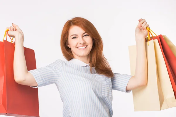 Retrato de joven mujer pelirroja feliz con bolsas de compras sobre fondo blanco — Foto de Stock