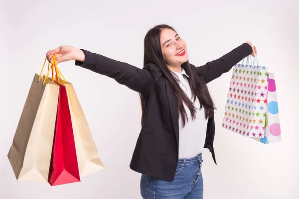 Retrato de jovem morena feliz com sacos de compras no fundo branco — Fotografia de Stock