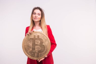 Büyük bitcoin beyaz arka plan üzerinde tutan çilli kadın. Cryptocurrency yatırım kavramı.
