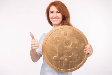 Beyaz arka plan üzerinde gösterilen ve büyük bitcoin tutarak Kızıl saçlı kadın yaşasın. Cryptocurrency yatırım kavramı.