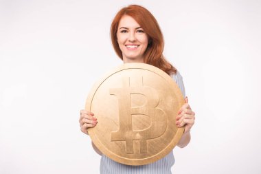 Büyük bitcoin beyaz arka plan üzerinde tutan Kızıl saçlı kadın. Cryptocurrency yatırım kavramı.