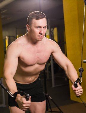 Spor salonunda egzersiz yapan kaslı bir adam. Güçlü erkek, çıplak karın kasları.