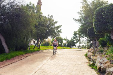 Genç bir adam bir parkta Bisiklete binmek.