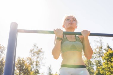 Aktif ve genç kadının pullups yapması.