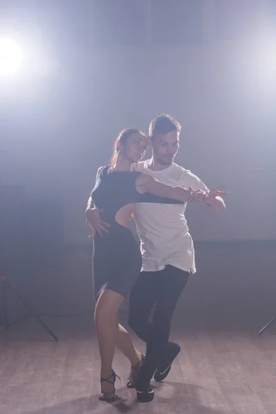 Pareja joven bailando social danse kizomba o bachata o semba o taraxia en clase de baile fondo — Foto de Stock