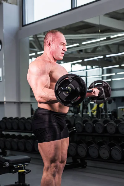 Kulturista muž s perfektní biceps, triceps a hrudníku v tělocvičně — Stock fotografie