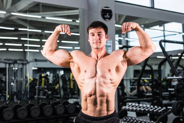 Culturista con bíceps, tríceps y pecho perfectos en el gimnasio — Foto de Stock