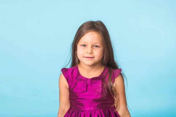 Söt glada lilla tjej porträtt, isolerad på blå bakgrund — Stockfoto