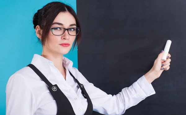 Menschen und Bildung. Lehrer schreibt während des Unterrichts an Mathe-Gleichung auf Tafel. — Stockfoto