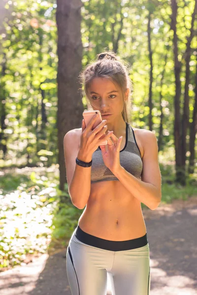 Active girl using fitness tracker smart watch jogging on summer nature outdoors looking at health data during sports activity — Stock Photo, Image