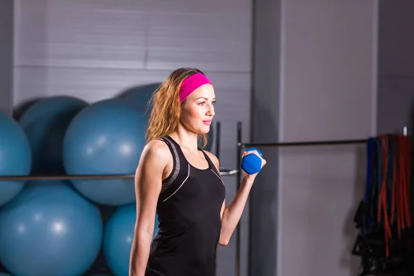 スポーツ、フィットネス、トレーニング、幸福の概念 - 光とスポーティな女性手青ダンベル — ストック写真