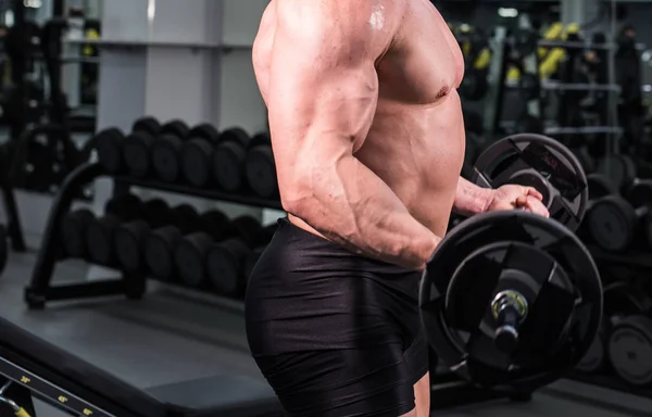 Primer plano del hombre culturista con grandes músculos en el gimnasio — Foto de Stock