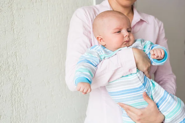 Amando jovem mãe segurando seu filho dentro de casa — Fotografia de Stock