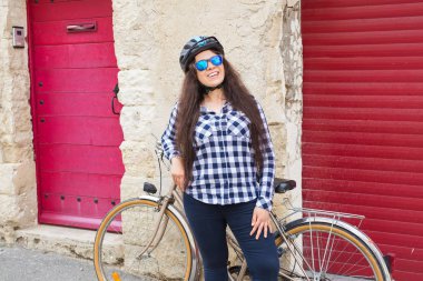 Bisiklet ve kask sokakta güneşli güzel genç kadın