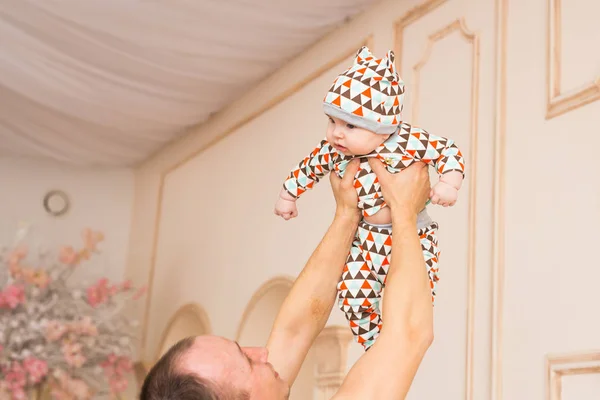 Jovem feliz segurando um bebê filho — Fotografia de Stock
