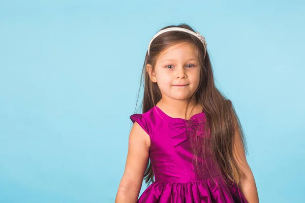 Söta glada lilla flicka porträtt, isolerad på blå bakgrund med kopia utrymme — Stockfoto
