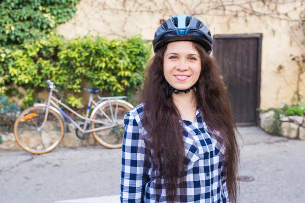웃는 여자 헬멧 배경 자전거와 골목에 위치 — 스톡 사진