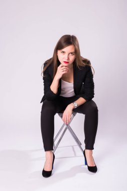 Studio, beyaz arka plan üzerinde izole resmi takım elbise poz esmer saçlı beyaz çekici kadın modeli