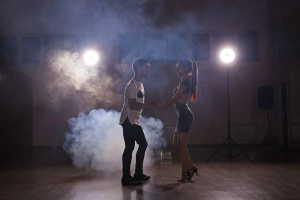 Pareja joven bailando baile latino Bachata, merengue, salsa. Dos poses de elegancia en clase de baile — Foto de Stock