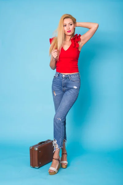 Verano, viajes, personas y vacaciones concepto - mujer rubia joven de moda con maleta retro aislado sobre fondo azul —  Fotos de Stock
