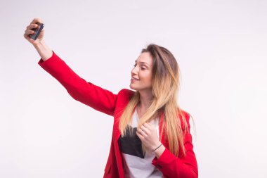 Güzel genç kadın kırmızı ceketli yapma Selfie