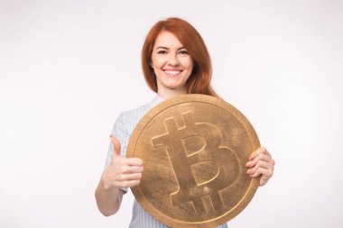 Beyaz arka plan üzerinde gösterilen ve büyük bitcoin tutarak Kızıl saçlı kadın yaşasın. Cryptocurrency yatırım kavramı.